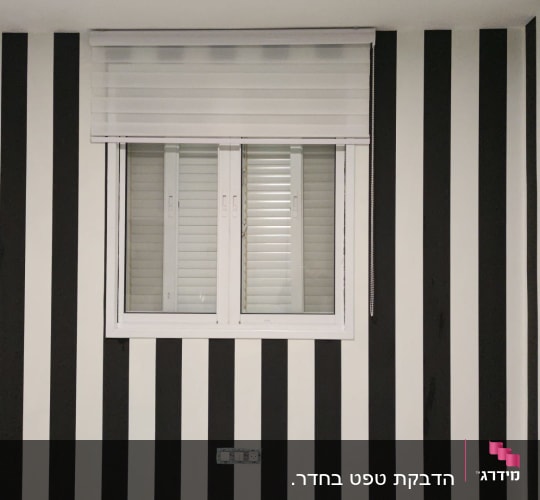 קיר עם טפט פסים בשחור ולבן ושעון גדול